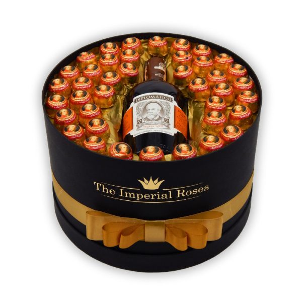 darčekový kôš pre muža čierny okrúhly box s mozzartovými guľami a fľašou rumu Diplomatico obmotaný zlatou stuhou a s nálepkou The Imperial Roses