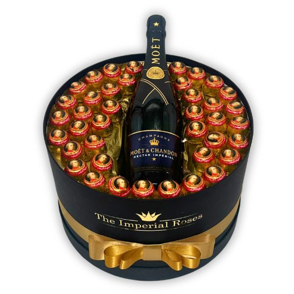 darčekový kôš pre muža čierny okrúhly box s mozzartovými guľami a fľašou šampanského Moet Chandon obmotaný zlatou stuhou a s nálepkou The Imperial Roses